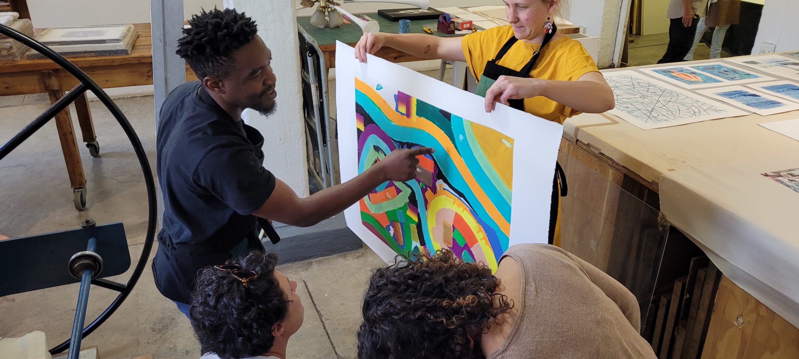 Khotso Motsoeneng (left) talking about his print just pulled from the press by Sarah Judge (right) with Anthea Buys (bottom left) and Kim-Lee Loggenberg (bottom right)